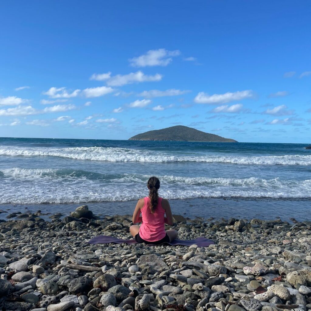 Kim doing yoga on the beach for yoga and coaching